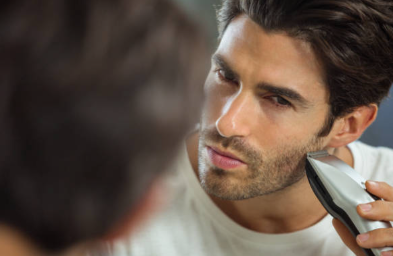 hombre frente a un espejo con una recortadora o trimmer, cuidado personal, SP Barber